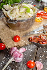 dumplings made of red and white fish meat, in a vintage rustic bowl plate, fork knife spoon, salt,...