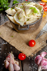 dumplings made of red and white fish meat, in a vintage rustic bowl plate, fork knife spoon, salt,...