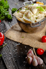dumplings made of red and white fish meat, in a vintage rustic bowl plate, fork knife spoon, salt,...