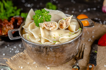 dumplings made of red and white fish meat, in a vintage rustic bowl plate, fork knife spoon, salt,...