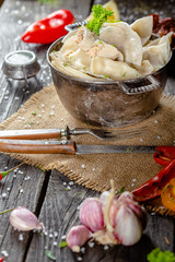 dumplings made of red and white fish meat, in a vintage rustic bowl plate, fork knife spoon, salt,...