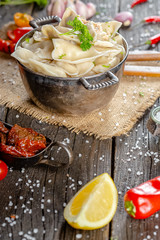 dumplings made of red and white fish meat, in a vintage rustic bowl plate, fork knife spoon, salt,...