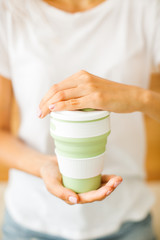 Obraz na płótnie Canvas Female hands hold reusable coffee mug.