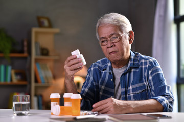 Asian senior man  with his medicine bottles