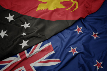 waving colorful flag of new zealand and national flag of Papua New Guinea.