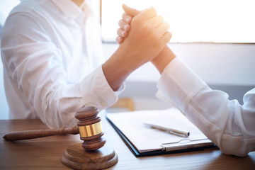 Two aggressive businessman compete arm wrestling with lawyer hammer in workplace.