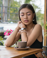 Asian smile  girl  in a cafe. Beautiful Balinese women with a cup of coffee