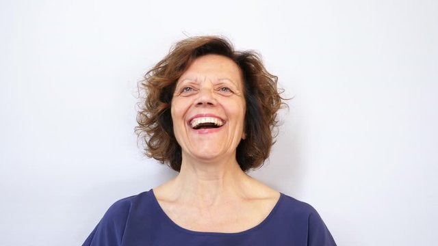Beautiful mature woman full of happiness isolated on white background. Filmed in 4K