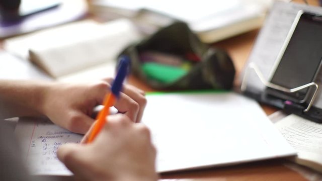 Students write in notebooks. Students use cheat sheets.  Students sit in school.