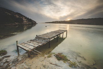 Obraz premium Wide angle landscape image of an old jetty on an estuary.