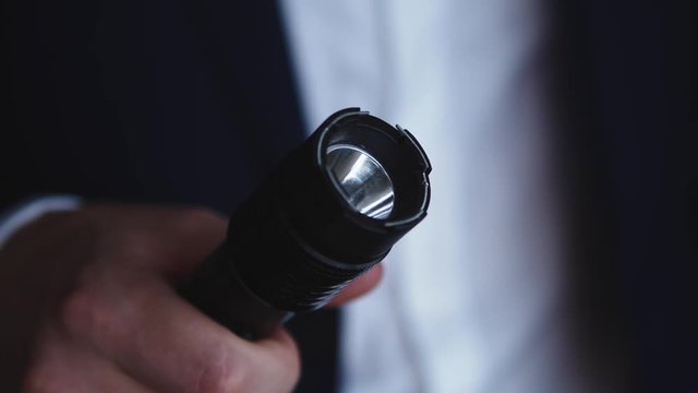 Electric Taser in the hand of the businessman. Stun Gun or electroshock weapon extreme close up shot
