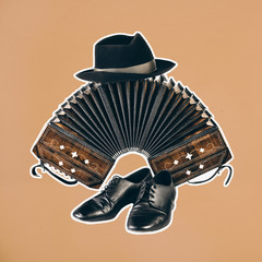 Bandoneon, tango instrument withpair of male dancing shoes and a hat on top with white border on orange