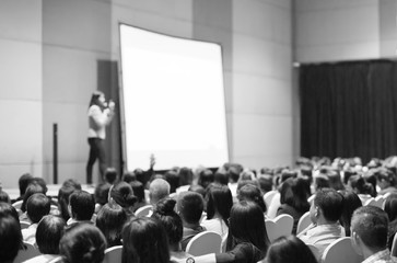 Seminar presenter at corporate conference giving speech. Woman speaker giving lecture to forum...