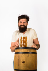 Wooden barrel and glass of beer. Oktoberfest. Bearded man with glass of beer. We meet oktoberfest. Germany traditions. Man holding mug of beer. Concept of craft beer.