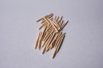 Wooden toothpicks lie in different forms on the table.            
