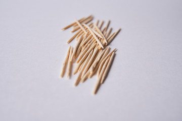 Wooden toothpicks lie in different forms on the table.            