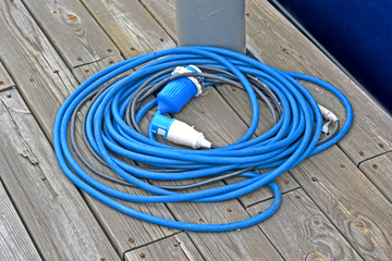 power cable roll with waterproof connector on vintage wooden surface, energy outage, electric tools...