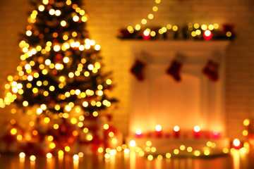 Blurred background of decorated fireplace near christmas tree