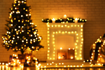 Blurred background of decorated fireplace near christmas tree