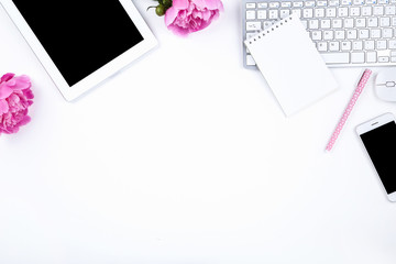 Tablet, keyboard computer with peony flowers, smartphone, notepad on white background
