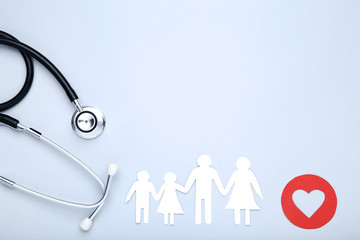 Family figures with red heart and stethoscope on grey background