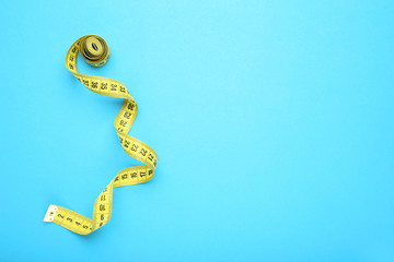 Yellow measuring tape on blue background