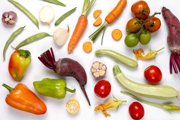 Pattern made of autumn vegetables. Food concept. Tomatoes, onion, cucumber, carrot, garlic, red beet, pepper, zucchini, maize and green haricot on white background. Flat lay, top view, copy space