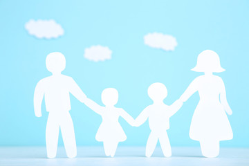 Paper family figures with clouds on blue background