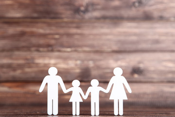 Family figures on brown wooden background