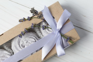 Lavender marshmallows in craft packaging. Tied with a ribbon with a bow. Several branches of lavender are woven into the bow.