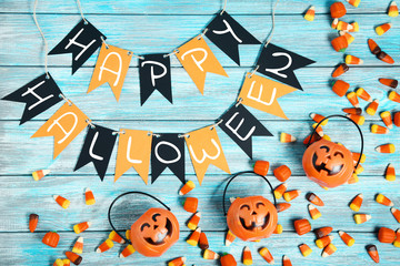 Halloween candy corns and pumpkins on blue wooden table