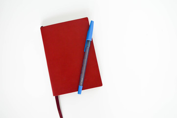 red notes book with a blue pen