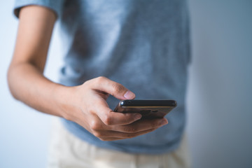 Concept technology: female one hand texting by using mobile phone side view
