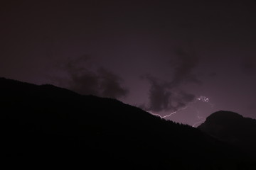 lightnings in the mountains on a black and purple background. Lighting bolt, lightning
