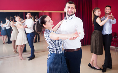Young dancing couples enjoying foxtrot