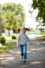 Portrait of a little girl running in a park