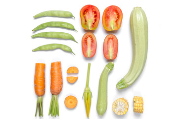 Pattern made of haricot, tomatoes, corn, carrot, zucchinion white background . Flat lay, top view, copy space. Healthy eating concept.