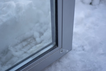 The glass door stuck (does not opening) next to snowdrift after winter storm.