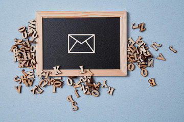 Email marketing and message online. Wooden letters and chalkboard