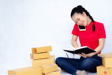 Asian women in a red shirt, blue pants, she smiled and held several brown boxes at the same time isolated white background.Women send parcels.