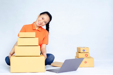 Asian women a orange shirt. she smiled and held several brown boxes at the same time isolated white background.Women send parcels.