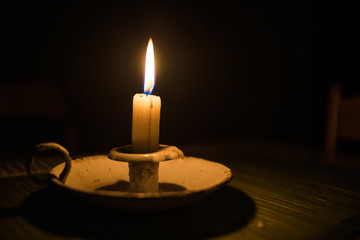 Close up image of a candle burning in a dark room