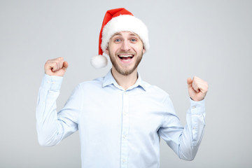 Portrait of young man with santa hat on grey background