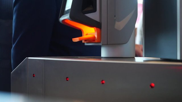 Close-up of people passing electronic turnstile with barcode scanner. Media.Electronic access control indoor security system side view