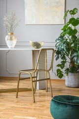 Fototapeta na wymiar Fancy golden chair at small dining table in chic living room
