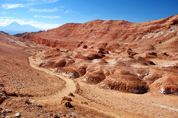 Desert landscape of the Moon Valley near San Pedro de Atacama, in the northern part of Chile, against a blue sky covered by clouds.