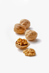 group of cracked walnuts cloth on a white backdrop in a soft backlight
