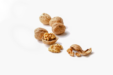 group of cracked walnuts cloth on a white backdrop in a soft backlight