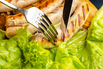 homemade hotdog sausages fried from red and white fish meat, in a vintage rustic plate bowl, fork...