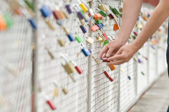 Germany, Bavaria, Munich, Man locking love lock